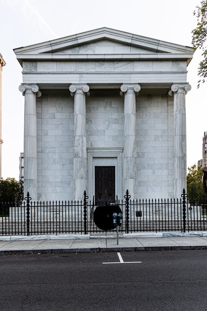 A classical building with pillars and a gated entrance.