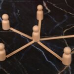 Wooden figurines arranged in a circular formation on a dark surface